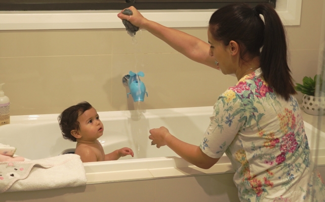 Image of parent supervising child in the bath. Water safety in the bath. 